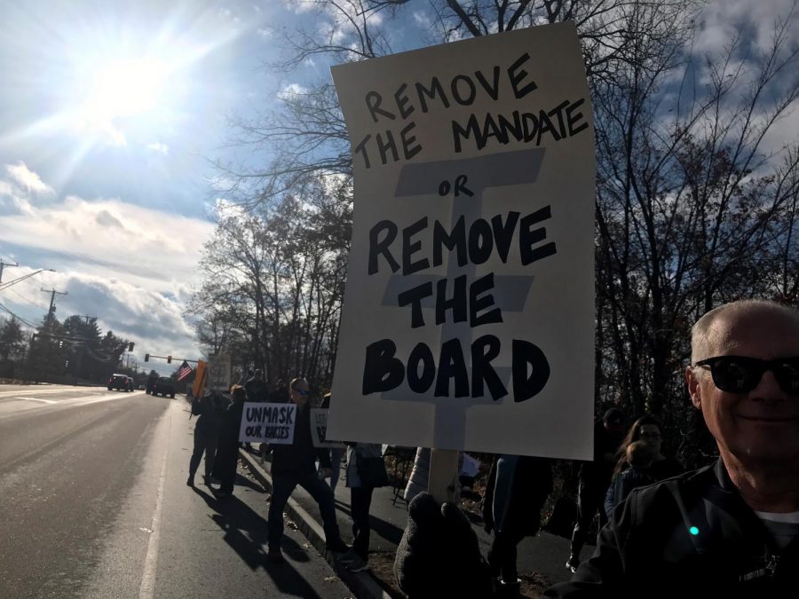 Residents and students protest in opposition to the mask mandate implemented by the school board. Some signs even call for the removal of school board members.