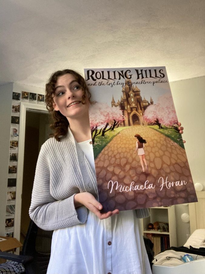 Horan holds a large poster of her book that was used for her book signing. This event was held on Saturday Oct. 30, at Ovation Theatre Company.