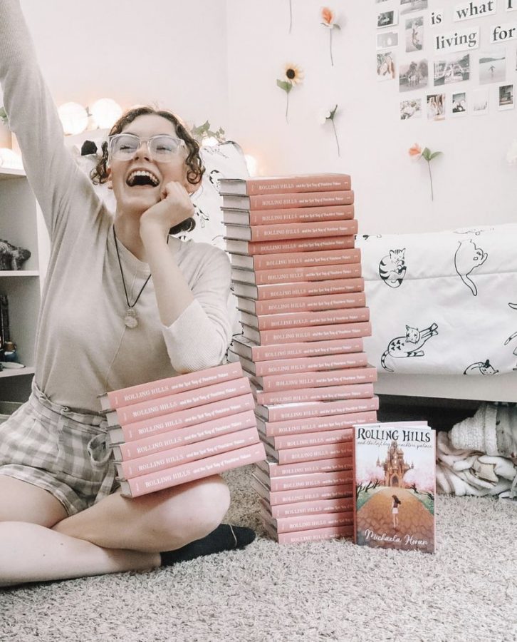  Horan sits next to a large stack of her books in her room. These books were brought to her book signing for the people that hadn’t already purchased them.