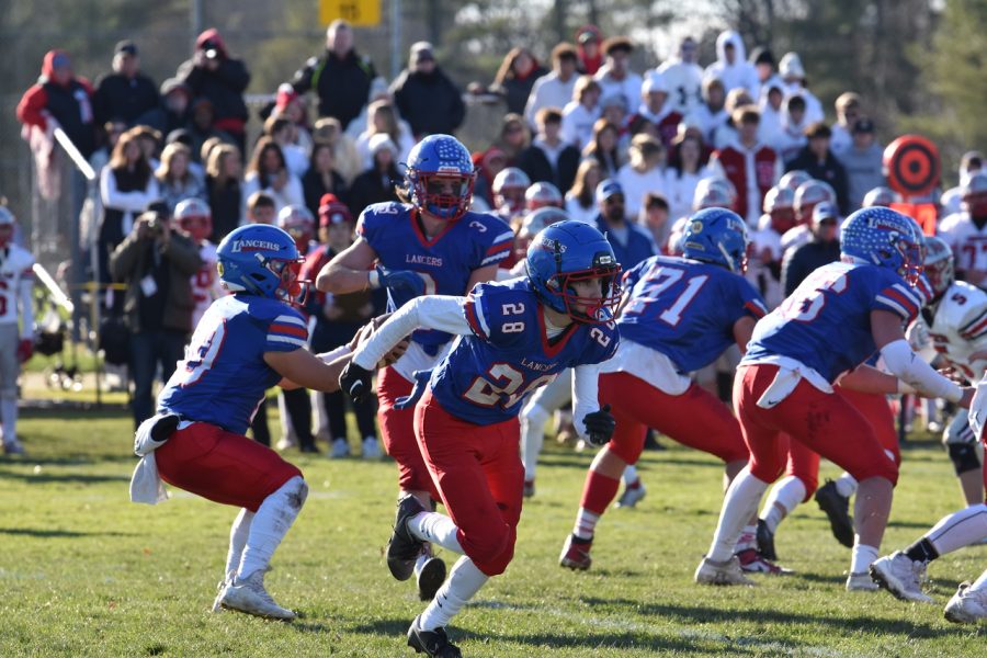 #10 senior Drew Heenan, #3 senior Trevor Weinnman, and #28 junior Jake Schena execute a play.