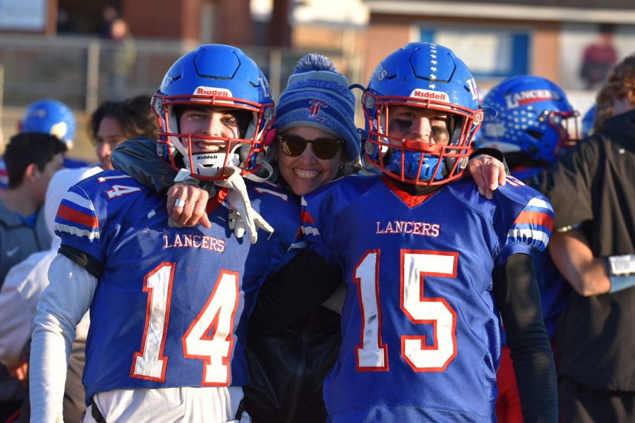 #14 junior Conor Williams and #15 junior Jake Perron take a photo with LHS Athletic Trainer Michelle Hart Miller.