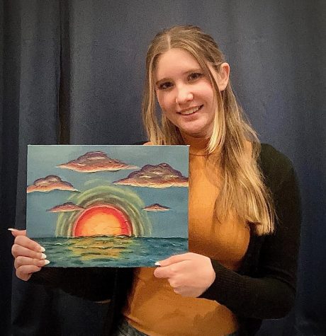 Senior Danielle Goodall proudly holds one of her many art pieces on display. Goodall has been drawing since the age of 3 and plans to pursue a career in graphic art after high school.