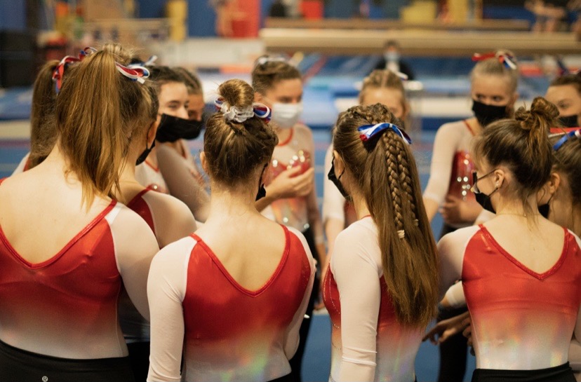 The girls put their hands in and huddle together to encourage one another before their meet last season.
