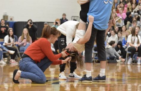 Angel Killian Daron had his mom cut his hair while he was held upside down after playing the drums.