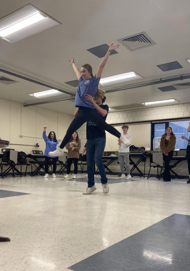 During dance rehearsal, sophomore Mason Turek lifts sophomore Julia Pizzi into the air while practicing their partner work in one of the dance numbers.