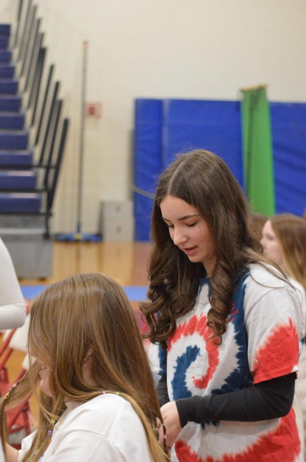Senior pep rally coordinator, Rebecca DePasse helps Junior, Sarah DeFazio with her ponytails. 