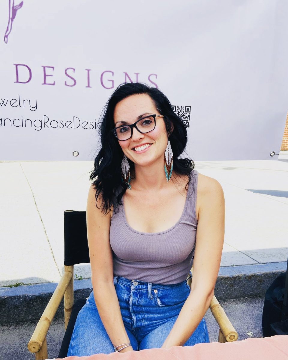 English teacher Ashley Day shows off her self-made earrings at a craft fair. Day sells her jewelry through her own business, Dancing Rose Designs. (Photo used with permission from Ashley Day).