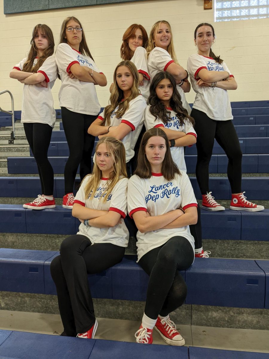 The pep rally team stand confidently while wearing their iconic red shoes. 
(Photo used with permission by Steven Juster).