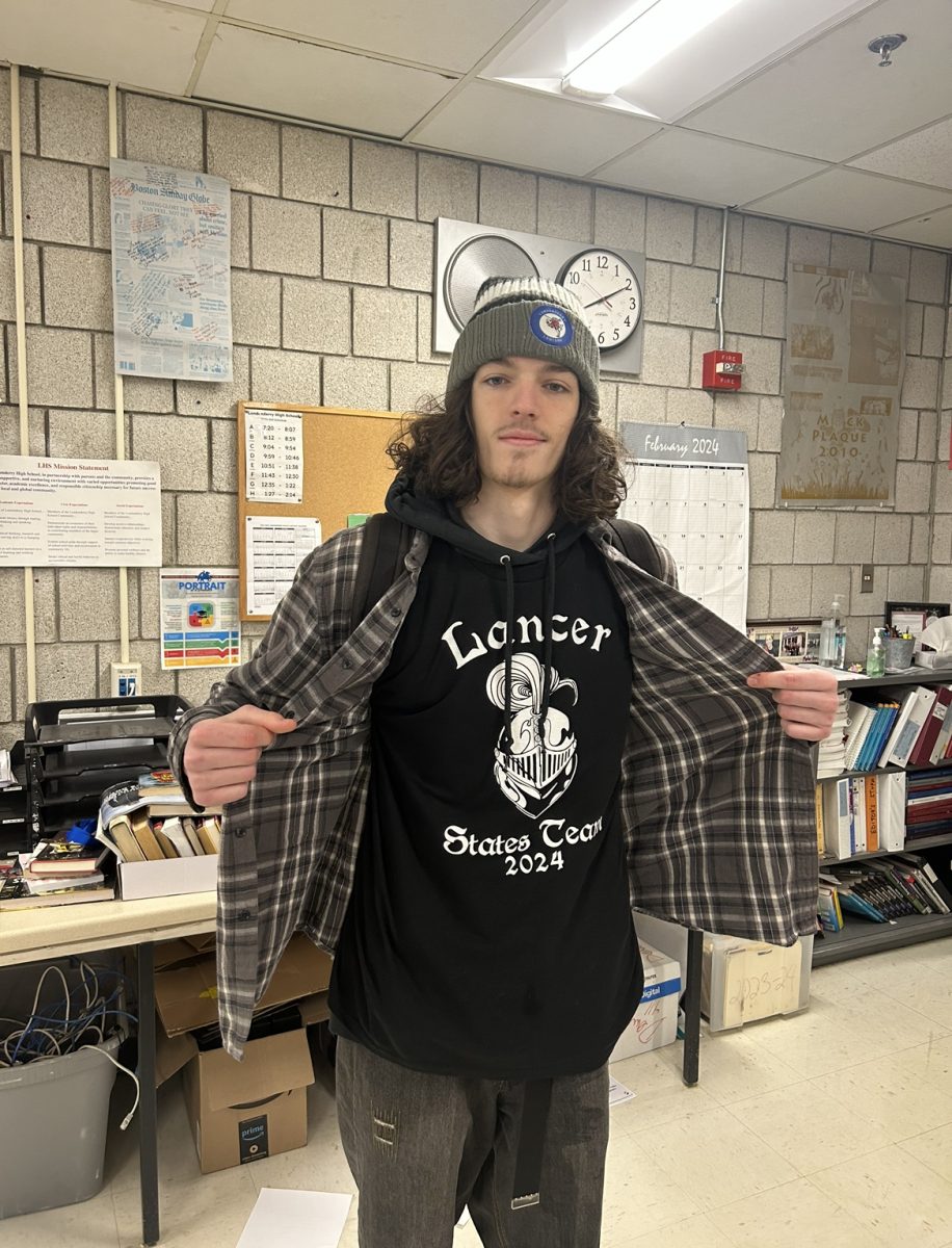 Junior Braedon Raduazzo showing off the swim team merch before state day.