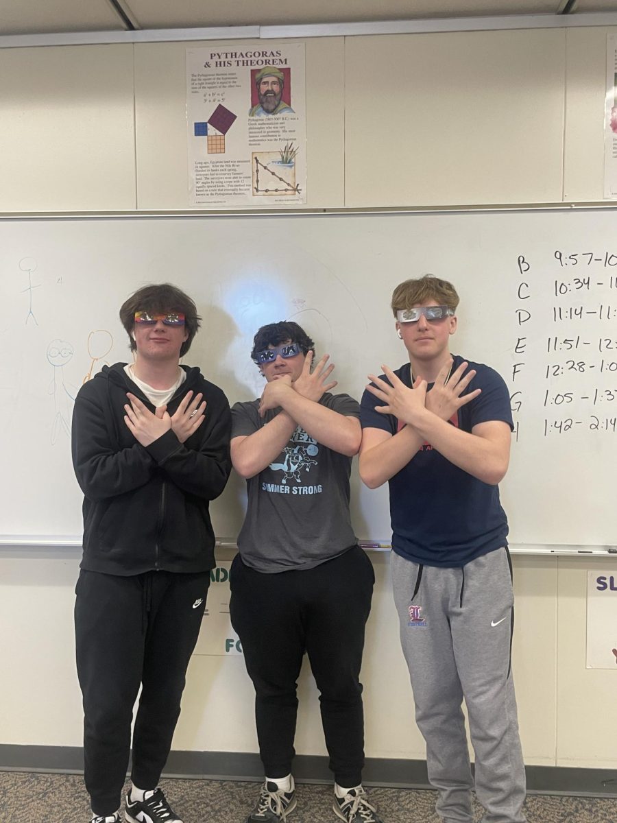 Sophomore Avery Yazbek, sophomore Joe Strong, sophomore Brandon Dyer (left to right) show their enthusiasm for the days track practice during the solar eclipse by showing off their eclipse eyewear. 
