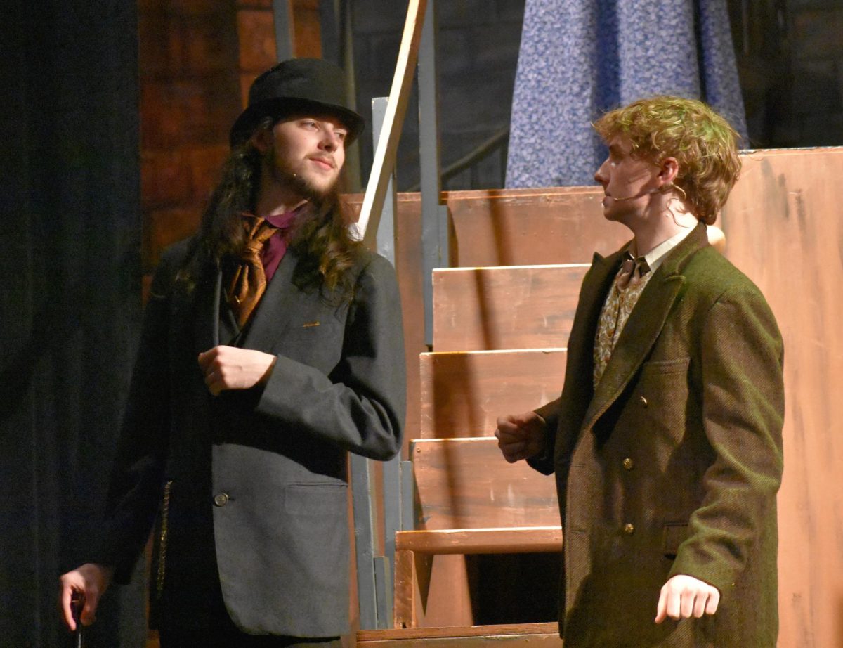 Senior Alex Barnes (Beadle) introduces their scene parter Cameron Fraser (Judge Turpin) during the masquerade scene. 