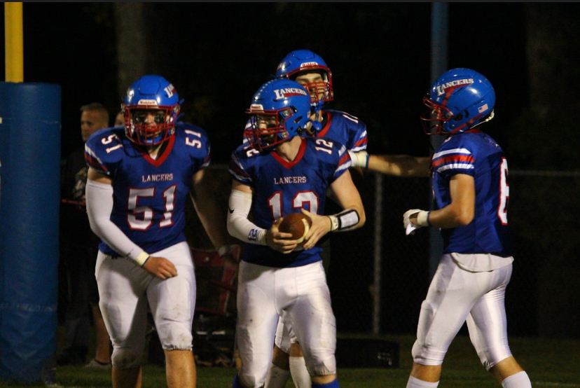 Quarterback Sam Ogden celebrates with his team after he scores a touchdown in a Friday night game at LHS.
