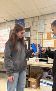 Freshman Elisa Thomas holds up her Venmo app for senior Lizzie Sosa to scan it to transact money.