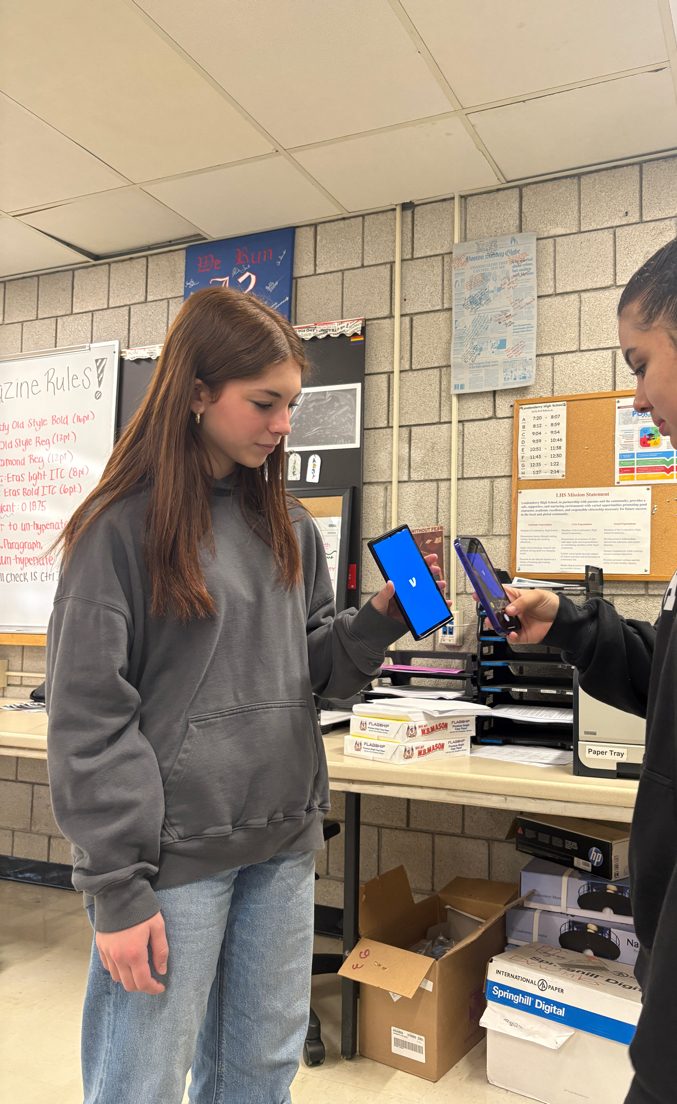 Freshman Elisa Thomas holds up her Venmo app for Senior Lizzie Sosa to scan it to transact money.