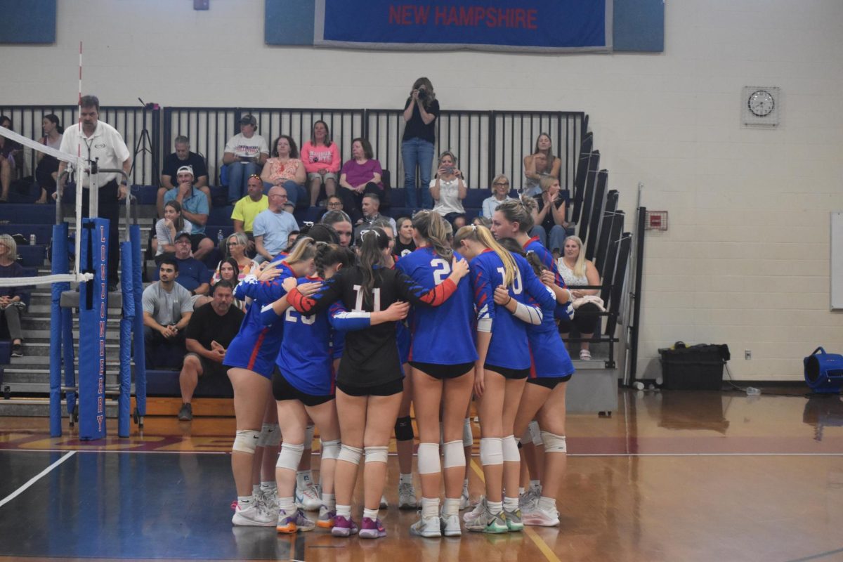 Girls varsity volleyball huddles before the start of their game to share final words of encouragement.