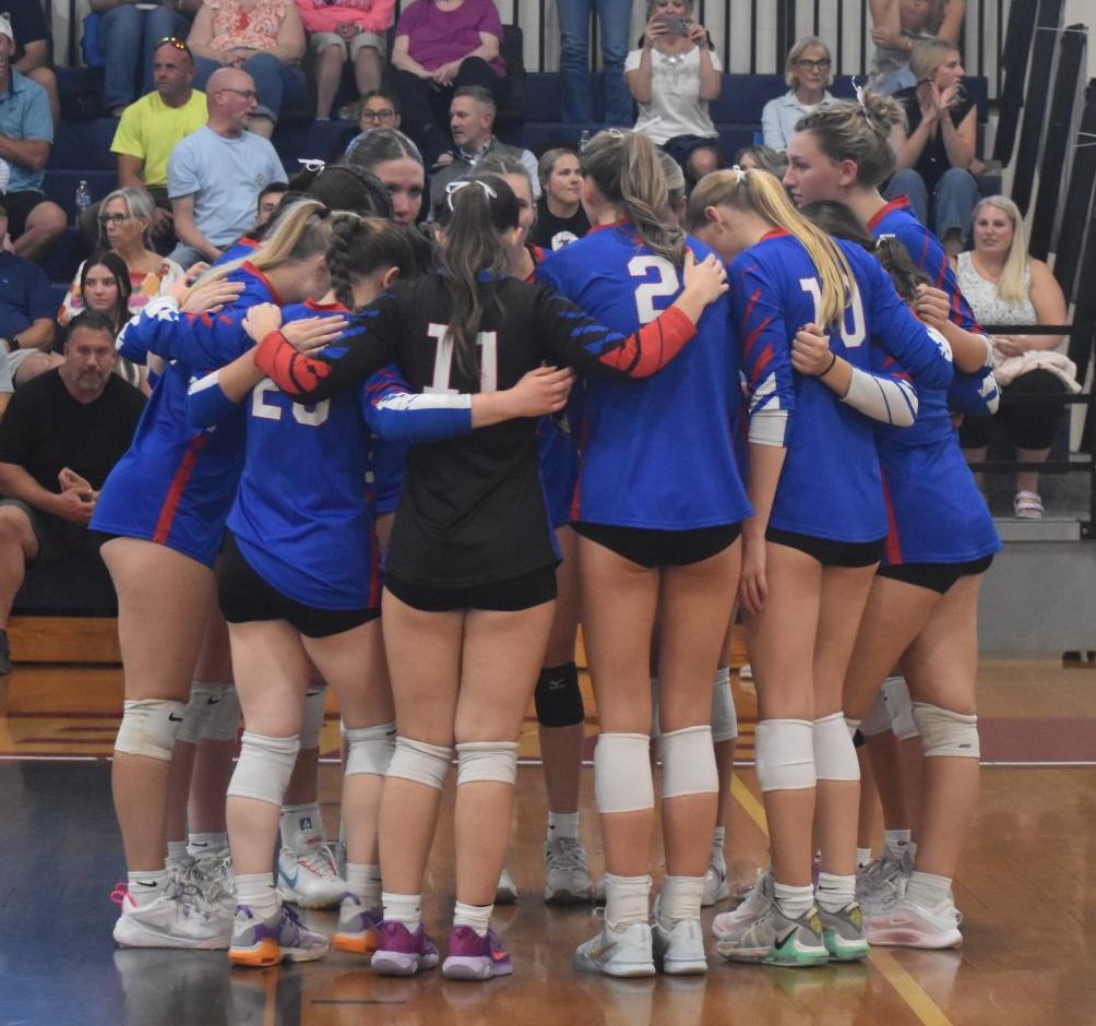Girls varsity volleyball huddles before the start of their game to share final words of encouragement.