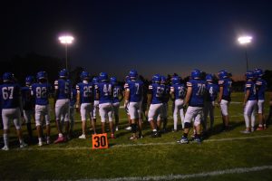 Under the Friday night lights, the Varsity Football Team stands united and ready to bring home the win.