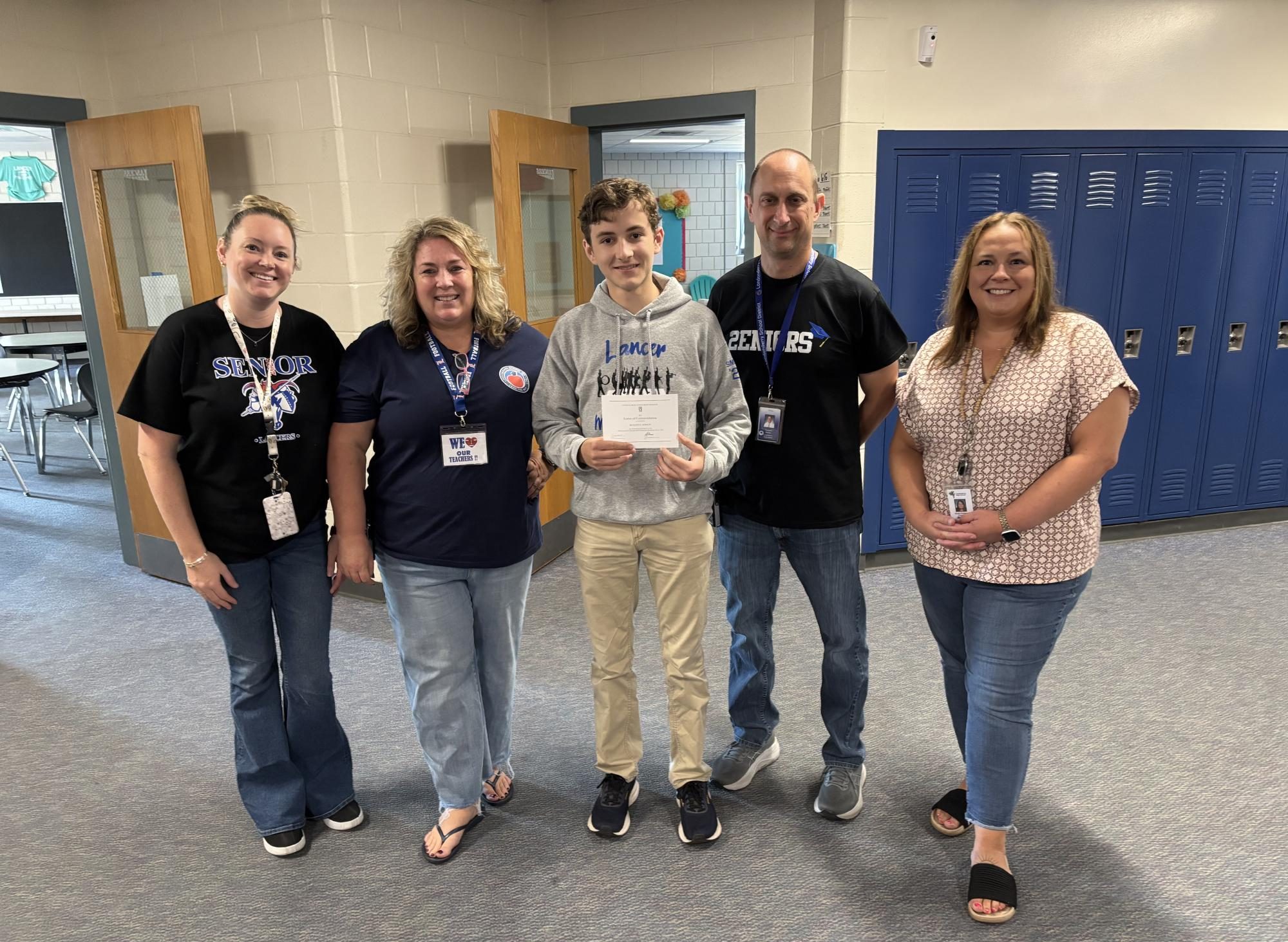 House 4 School Counselor Rhiannon Sumner, House 4 Assistant Principal Katie Sullivan, Principal Rick Barnes and House 2 𑁋formerly House 4𑁋 School Counselor Sarah Doherty congratulate senior Ben Simpson on his recognition as a Commended Student in the National Merit Scholarship program. He, along with seniors Jayden Wu, Simone Miller and Megan Petersen, placed in the top 50,000 2025 PSAT/NMSQT scorers in the country. According to Barnes, the admin team is “trying to start the tradition of bringing [students] down [to their house office] to give a quick celebration and acknowledgement to say, ‘hey, we recognize you, we see you doing the good work and we're proud of your achievement.’” (Photo used with permission by Kaitlin Burkhardt).