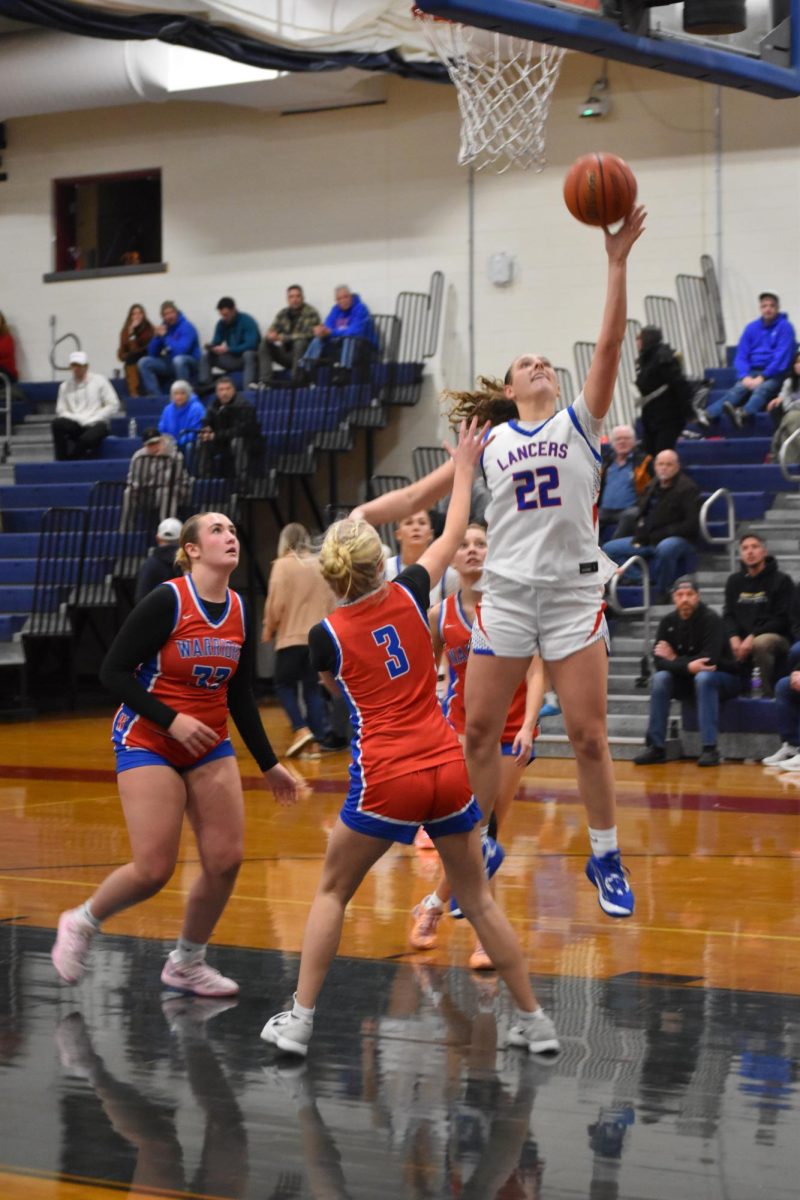 Senior Sammie Sullivan takes contested a layup over a Winnacunnet defender.