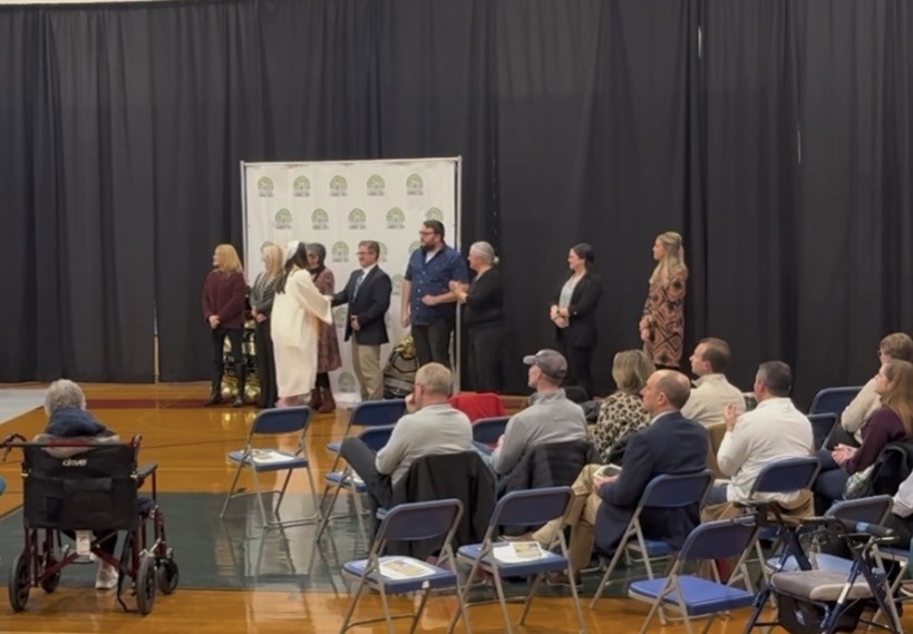 Advisors congratulate a student from the class of 2026.