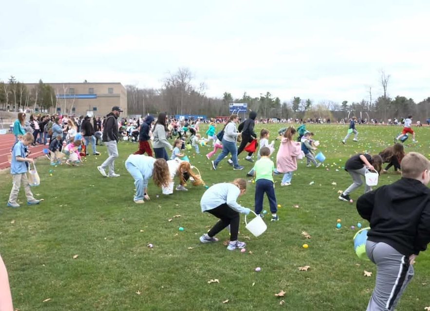 Kids rush onto the field with excitement, ready to see what is in the eggs.  