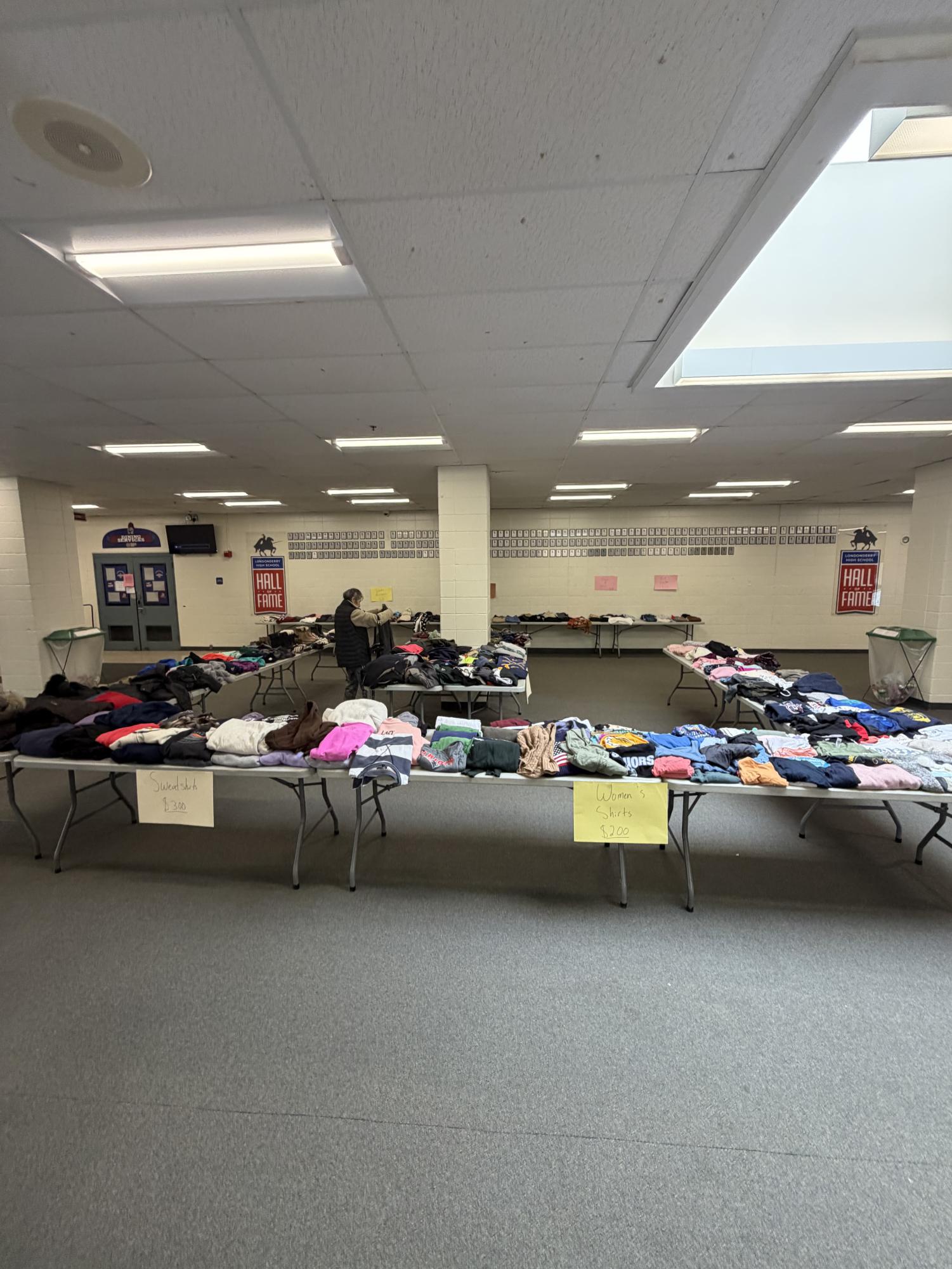 Clothing items are displayed for sale during the annual Green Council thrift affair, where community members gather to shop for affordable, gently used apparel and promote sustainable practices, in the LHS lobby on Dec. 13. (Image used with permission by Benjamin Bristol.)