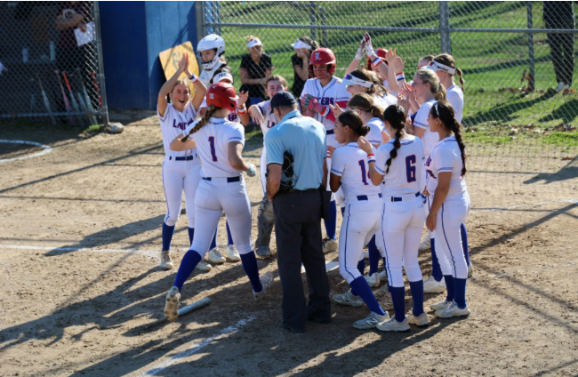 The Lancers celebrate and embrace their teammate following a home run from sophomore Paige Secor. (Photo used with permission from Alison Chambers)