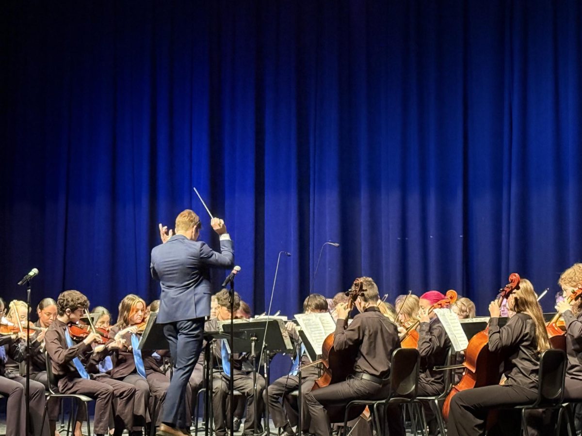 Assistant Band Director Devin DiBernardo conducts opening number during the orchestra and choir concert on May 15. 