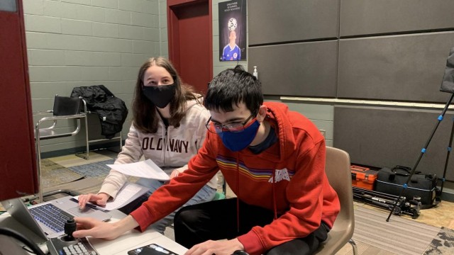 Media students, junior Ahna Gainey and senior Garret Calusdian sit in the press box overlooking the gym, where they oversee the livestream. Photo by Spencer McIntyre