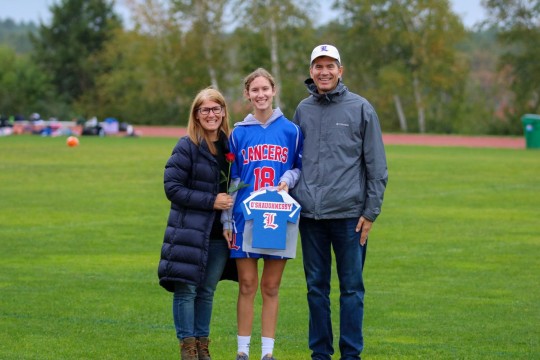 Helper Madelyn O'Shaughnessy and her parents celebrate Senior Night.