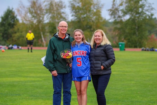 Helper Laura Bowen and her parents celebrate Senior Night.