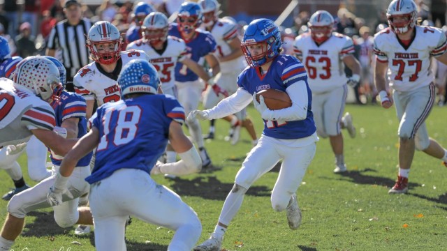 Andrew Kullman runs the ball while Colby Ramshaw blocks.