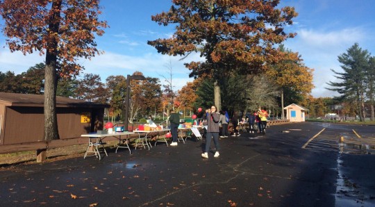 Tables of donation bins, free items, and raffle prizes lined up at the walk entrance.
