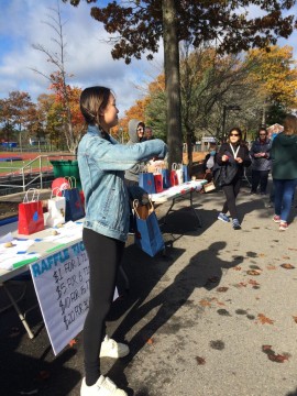 Senior Annabella Wu pulls raffle tickets to announce winners for the 25 raffle baskets