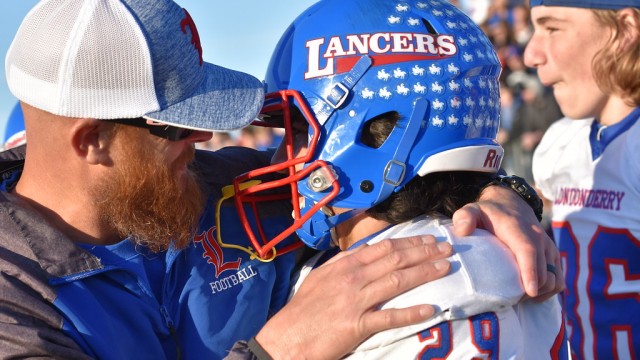 Coach Carey and kicker Dylan Wrisley embrace after The State Championship game.