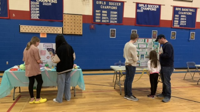 International Club Publicist, Aika Chen, explains Japanese culture and traditions to Grace McElroy while volunteer Michael Pitts explains Italian culture to Reece and David Sutherland.
(Pictured left to right: Grace McElroy, Aika Chen, Michael Pitts, Reece, Sutherland, and David Sutherland)