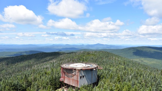 The view from the top is breathtaking with the mountains and the clouds.